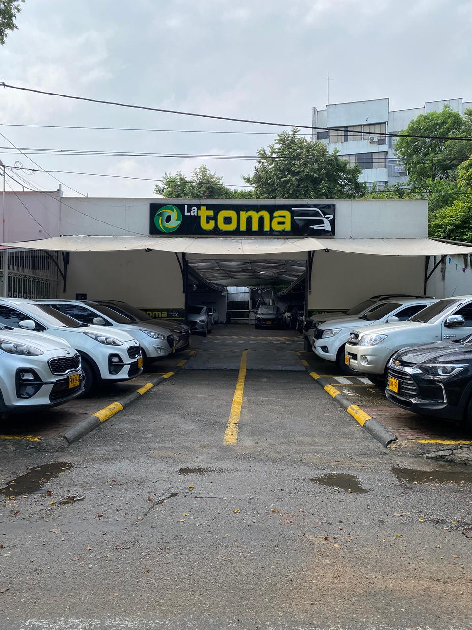 Entrada al patio de Autos La Toma con carros a ambos lados