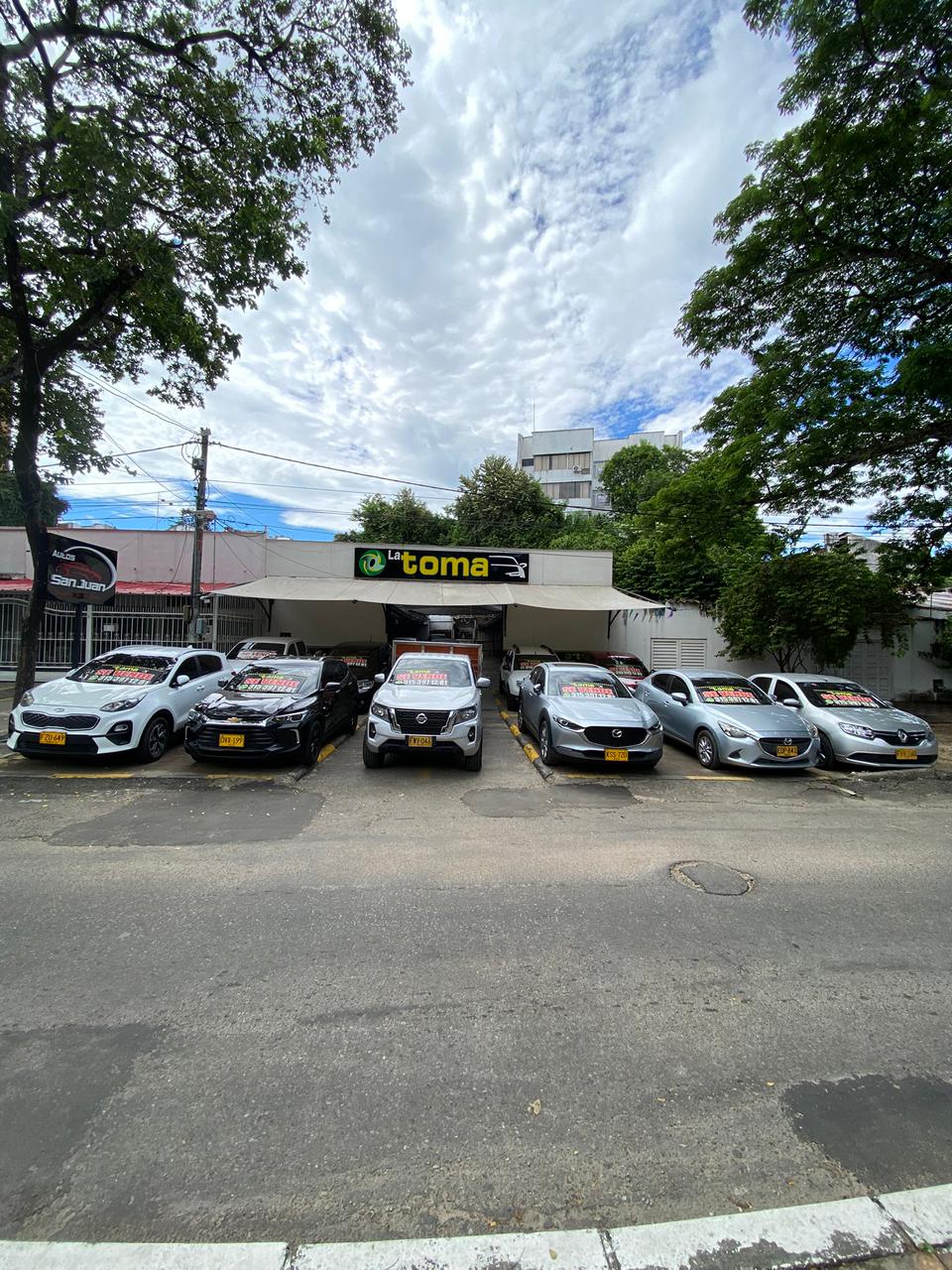 Fachada de Autos La Toma con vehículos usados exhibidos en Neiva