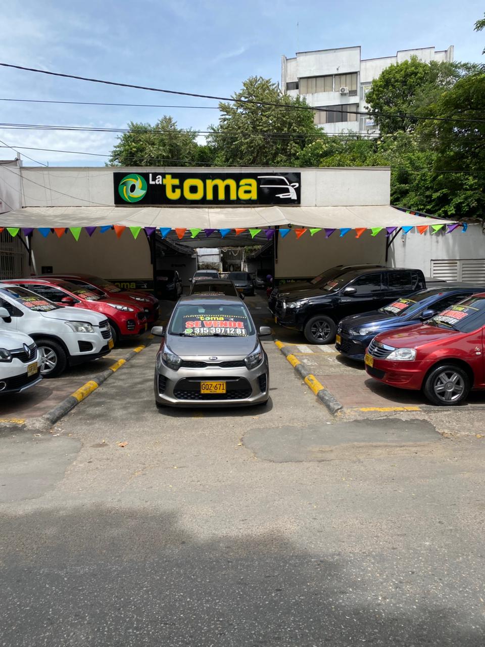 Vista frontal del patio de La Toma con varios carros en venta